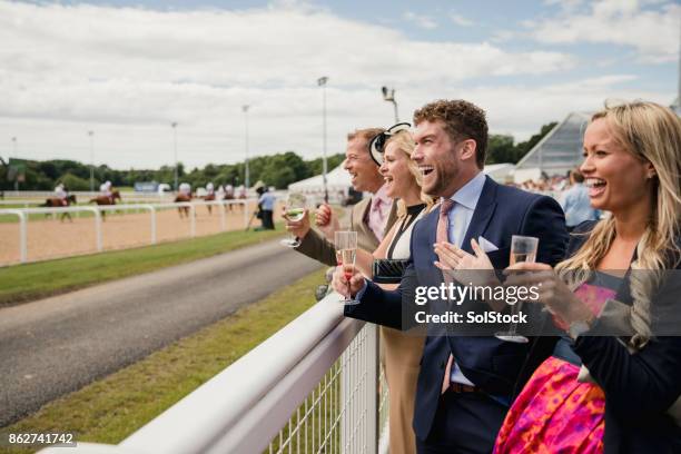 deux couples en sirotant une boisson - course hippique photos et images de collection