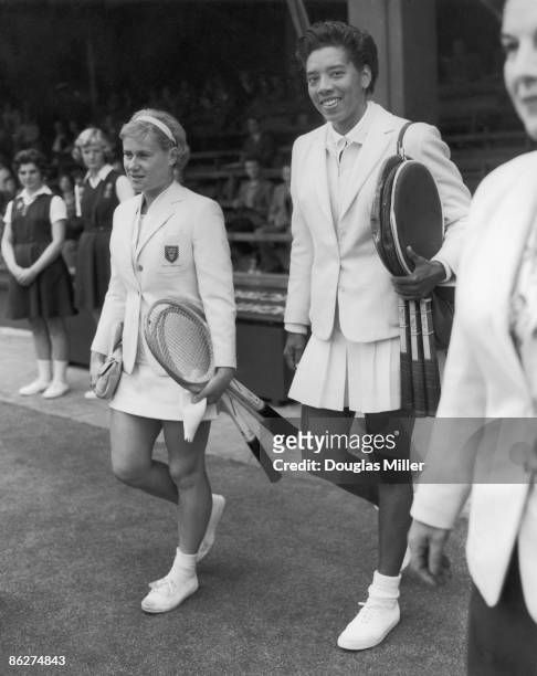 Tennis players Shirley Bloomer of Great Britain and Althea Gibson of the USA, walk onto the court before the opening match of the Wightman Cup at...