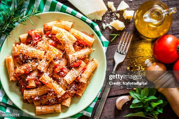 pastateller von oben am rustikalen holztisch erschossen - rigatoni stock-fotos und bilder