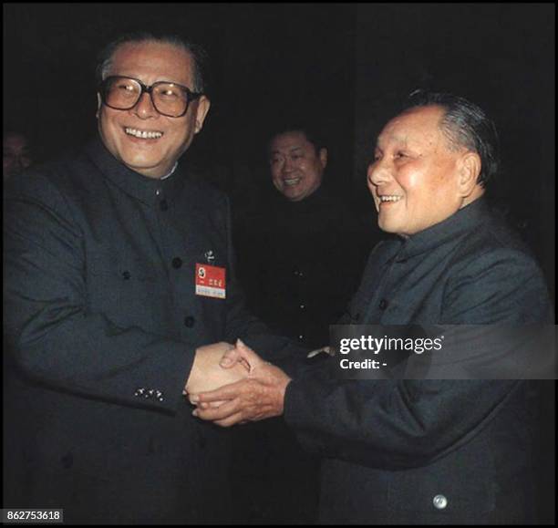 Chinese paramount leader Deng Xiaoping shaking hands with Chinese President Jiang Zemin at the end of the 14th Party Congress in Beijing October...