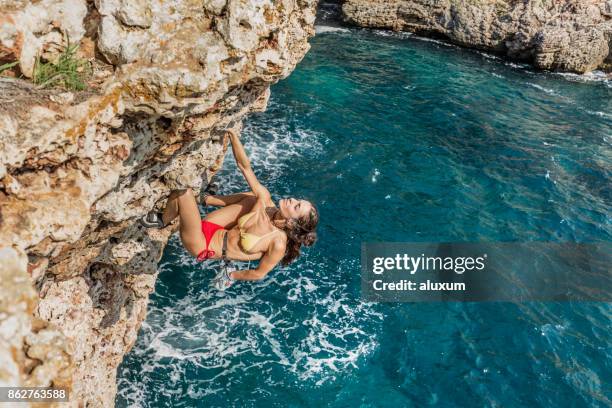 woman practicing psicobloc rock climbing in minorca spain - minorca stock pictures, royalty-free photos & images