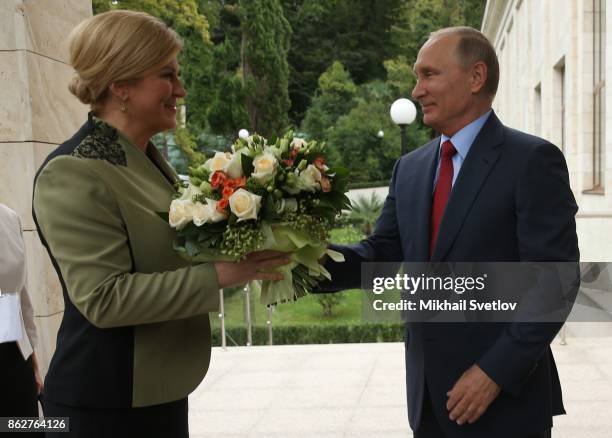 Russian President Vladimir Putin greets Croatian President Kolinda Grabar-Kitarovic during their meeting on October 18, 2017 in Sochi, Russia. The...