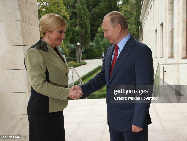 Russian President Vladimir Putin greets Croatian President Kolinda Grabar-Kitarovic during their meeting on October 18, 2017 in Sochi, Russia. The...