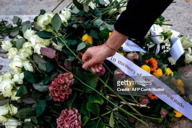 Person lays a white rose during a ceremony in support of victims of terrorism and emergency response services in Brussels, on October 18, 2017. The...
