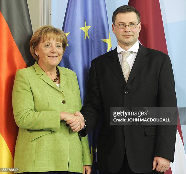 German Chancellor Angela Merkel shakes hands with Latvian Prime Minister Valdis Dombrovskis after a joint presss conference following talks at the...