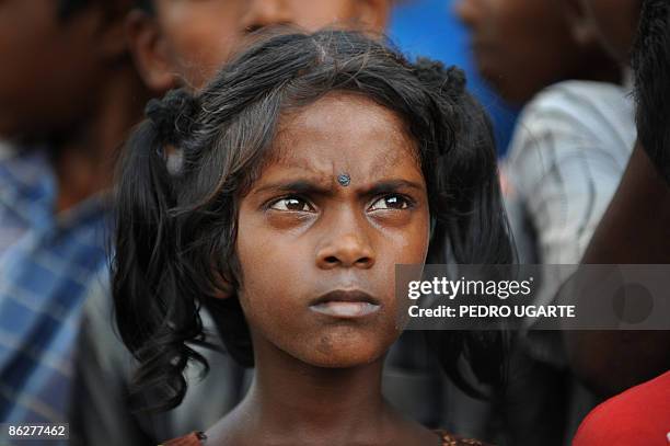 Displaced Tamil girl looks on as unseen French and British Foreign Ministers Bernard Kouchner and David Miliband arrive at Kadirgamh camp in...