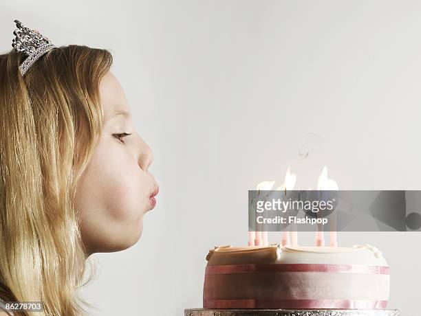 portrait of girl blowing out candles on cake - gateau anniversaire fond blanc photos et images de collection