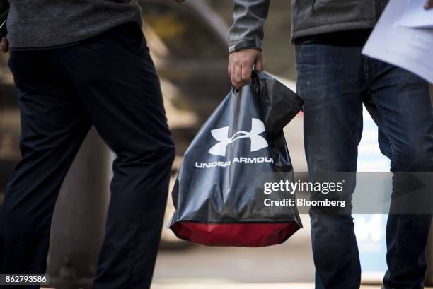 Pedestrian carries an Under Armour Inc. Shopping bag in downtown Chicago, Illinois, U.S., on Monday, Oct. 16, 2017. Under Armour must improve and...