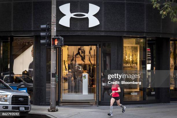 Woman runs past an Under Armour Inc. Store in downtown Chicago, Illinois, U.S., on Monday, Oct. 16, 2017. Under Armour must improve and expand its...