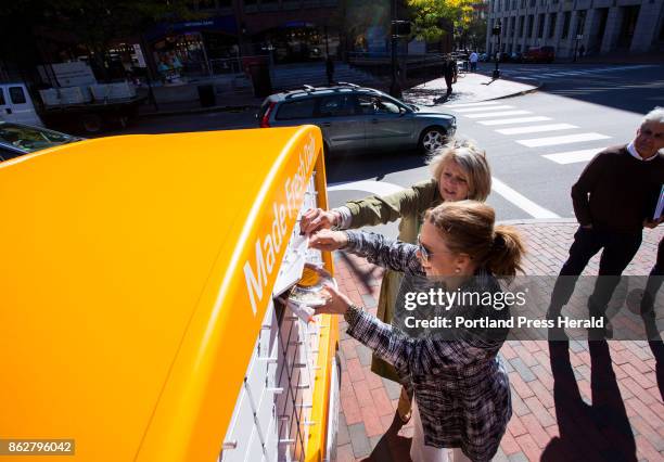 Veebie, a mobile fresh-food kiosk at the corner of Middle and Temple streets. Laura Sosnowski helps Terri Stevens, front, get her lunch from the...