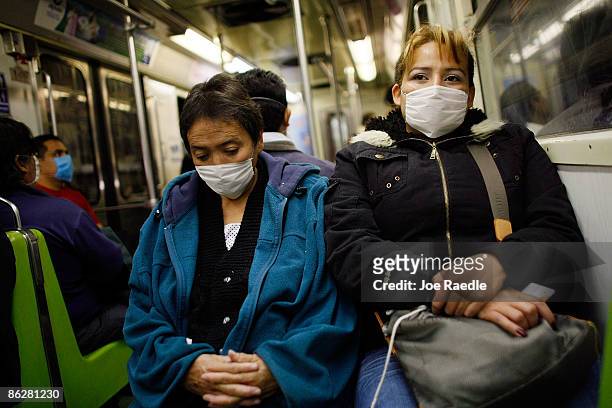 People wear surgical masks, to help prevent being infected with the swine flu, as they ride the subway on April 29, 2009 in Mexico City, Mexico....