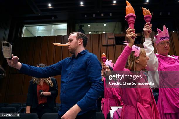 Oliver Mintz-Lowe takes a 'selfie' while protesting with members of Code Pink for Peace before the start of a hearing where U.S. Attorney General...