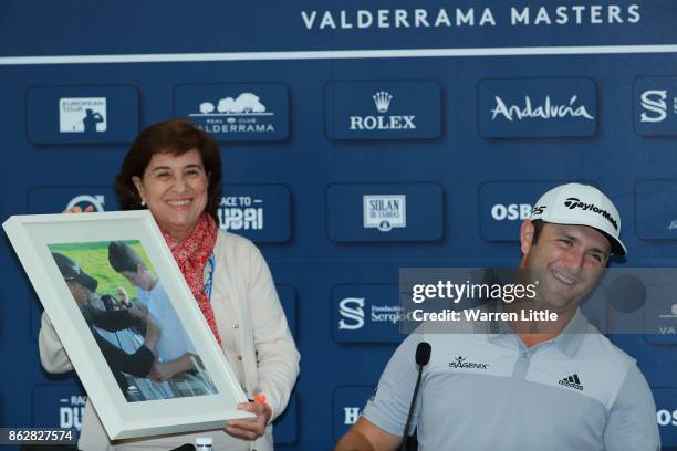 Jon Rahm of Spain is given a picture of himself receiving an autograph from Henrik Stenson taken over ten years ago by Maria Acacia Lopez Bachiller,...