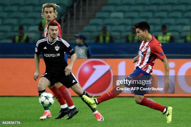 Atletico Madrid's midfielder from Argentina Nico Gaitan kicks the ball past Qarabag's defender from Azerbaijan Gara Garayev and Atletico Madrid's...