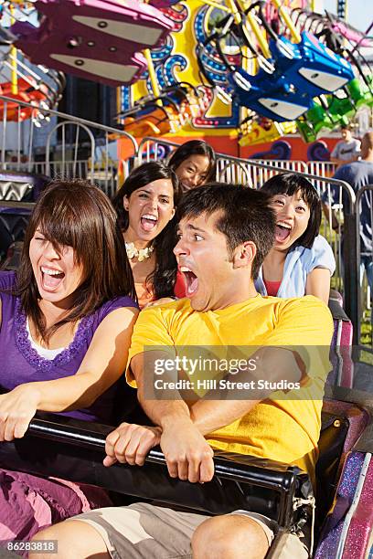 people on amusement park ride - young woman screaming on a rollercoaster stock-fotos und bilder