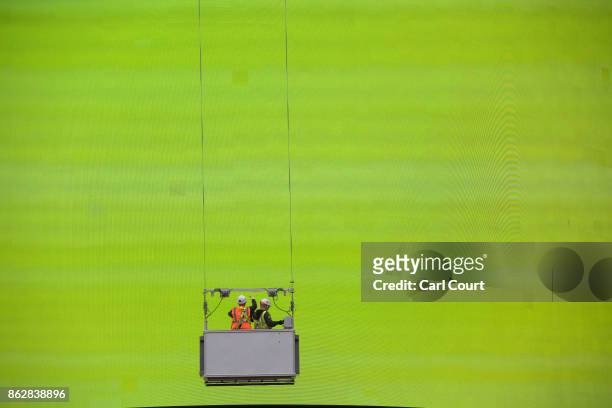 Workers check the Piccadilly Circus billboard as it displays a test screen on October 18, 2017 in London, England. After nine months of works to...