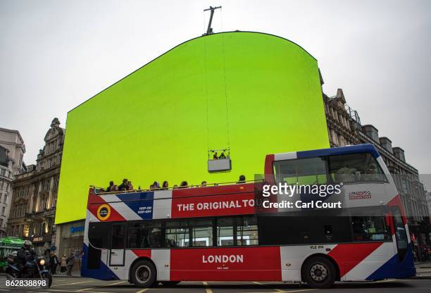 Sightseeing bus passes the Piccadilly Circus billboard as it displays a test screen on October 18, 2017 in London, England. After nine months of...