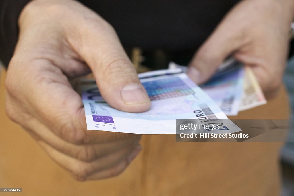 Hands holding Euro currency