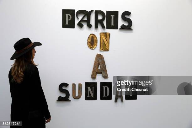 Visitor looks at an artwork entitled 'Paris On A Sunday' by US artist Jack Pierson at the Grand Palais as part of the FIAC international contemporary...