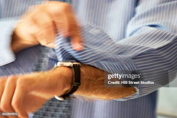 man rolling up sleeve - sleeve roll stock pictures, royalty-free photos & images