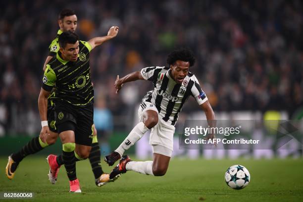 Juventus' forward from Colombia Juan Cuadrado vies with Sporting's Argentinian forward Marcos Acuna during the UEFA Champions League Group D football...