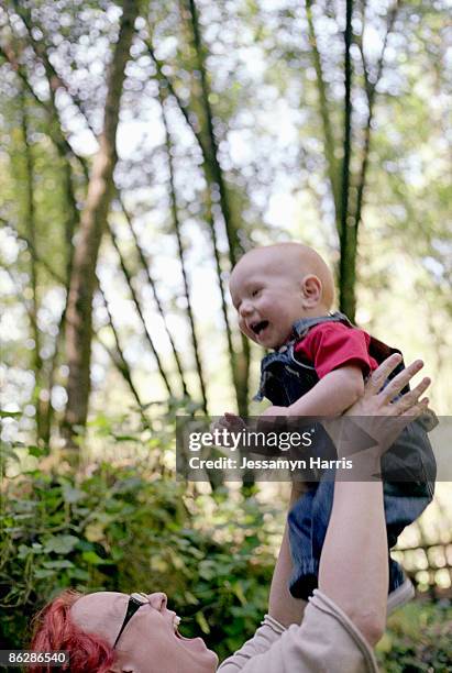 mother lifting baby boy - jessamyn harris stock pictures, royalty-free photos & images