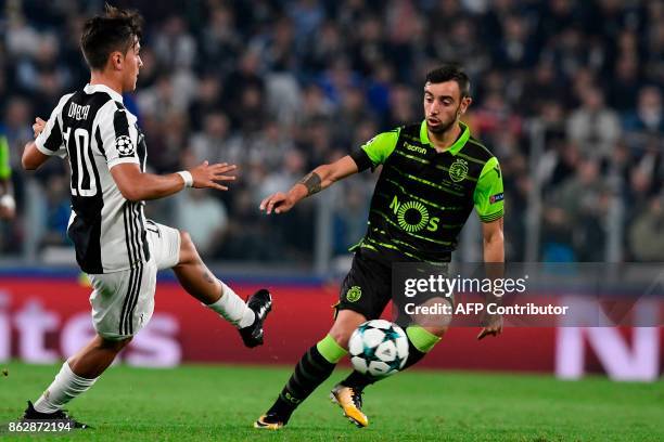 Juventus' forward from Argentina Paulo Dybala fights for the ball with Sporting's midfielder Bruno Fernandes during the UEFA Champions League Group D...