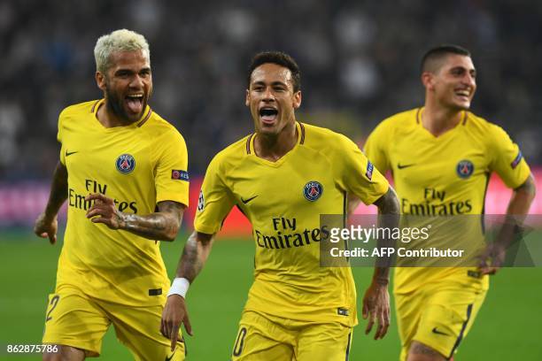 Paris Saint-Germain's Brazilian forward Neymar celebrates scoring a goal with Paris Saint-Germain's Brazilian defender Dani Alves and Paris...