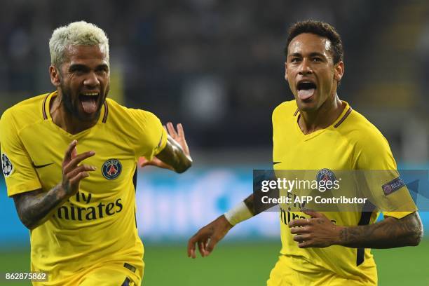 Paris Saint-Germain's Brazilian forward Neymar celebrates scoring a goal with Paris Saint-Germain's Brazilian defender Dani Alves during the UEFA...