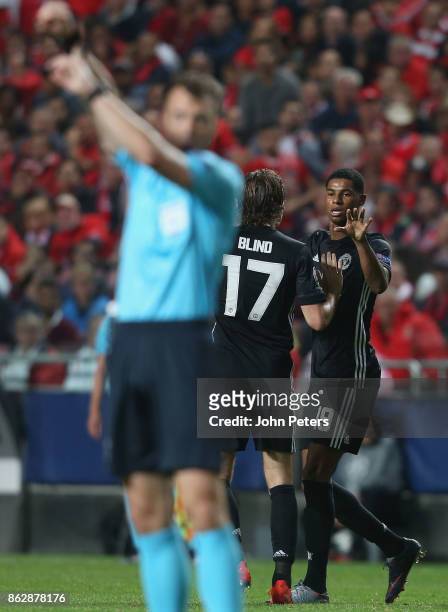Marcus Rashford of Manchester United celebrates scoring their first goal as referee Felix Zwayer points at his watch to show the ball crossed the...