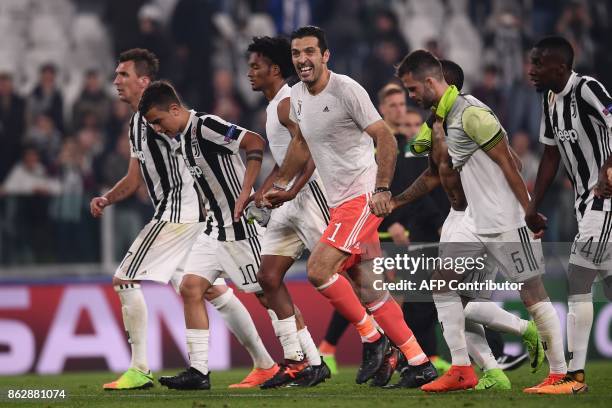 Juventus' goalkeeper from Italy Gianluigi Buffon celebrates with teammates at the end of the UEFA Champions League Group D football match Juventus vs...