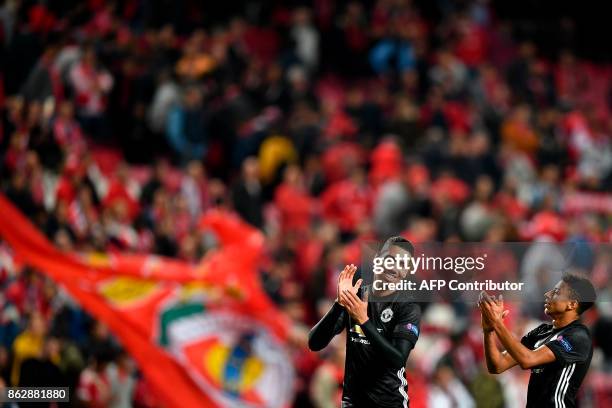 Manchester United's defender Chris Smalling and Manchester United's midfielder Jesse Lingard applaud at the end of the UEFA Champions League group A...