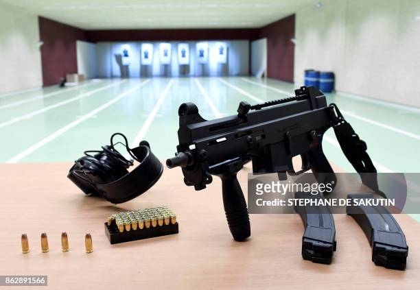 Picture taken on October 12, 2017 shows an HK UMP 9 mm weapon and ammunition at the new Paris Judiciary Police headquarters in Paris. The new...