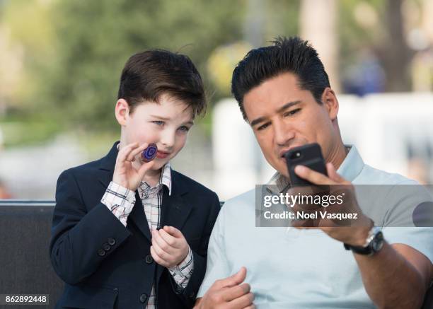 Iain Armitage shows off his rock to Mario Lopez at "Extra" at Universal Studios Hollywood on October 18, 2017 in Universal City, California.