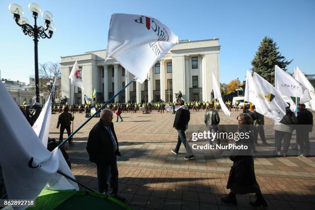 Protesters walk with a flags in front of Ukrainian Parliament in Kyiv, Ukraine, Oct.18, 2017. Dozens Ukrainians set up a tent camp in front of...