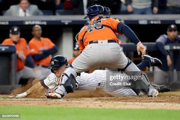 Brett Gardner of the New York Yankees slides in safely at home plate to score on a double by Aaron Judge against Brian McCann of the Houston Astros...