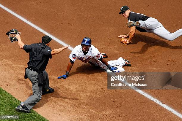 Third base umpire Jerry Meals makes the safe call as Jose Reyes of the New York Mets beats the tag from Wes Helms of the Florida Marlins for a first...