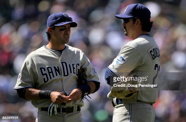 Second baseman Edgar Gonzalez and first baseman Adrian Gonzalez of the San Diego Padres await a pitching change against the Colorado Rockies in the...
