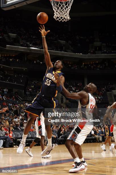 Roy Hibbert of the Indiana Pacers shoots a layup against Emeka Okafor of the Charlotte Bobcats during the game at Time Warner Cable Arena on March...