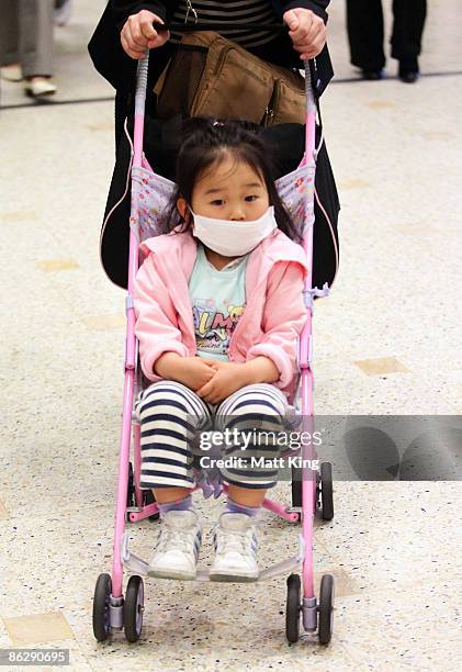Young child wearing a face mask arrives at Sydney International Airport on April 30, 2009 in Sydney, Australia. The World Health Organisation has...