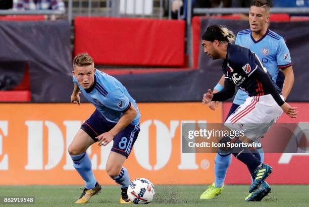 New York City FC midfielder Alexander Ring slips away from New England Revolution midfielder Lee Nguyen during a match between the New England...