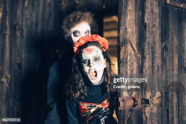 不気味なハロウィーンのマスクを叫んでの 10 代の少女少年 - zombie girl ストックフォトと画像