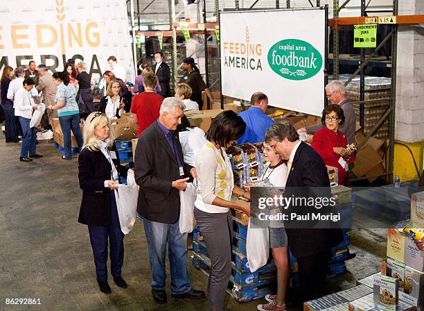 First lady Michelle Obama, along with congressional spouses and volunteers, fills plastic bags with non-perishable food items for distribution to the...