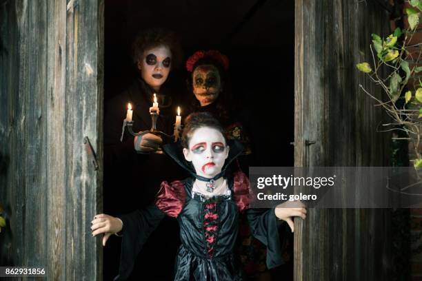 納屋のドアの後ろに隠れて不気味なハロウィーンの衣装で 3 人の子供 - zombie girl ストックフォトと画像