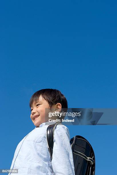 boy (6-7) wearing school bag, smiling - school boy with bag stock pictures, royalty-free photos & images