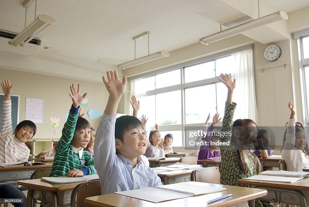 School children raising arms in class