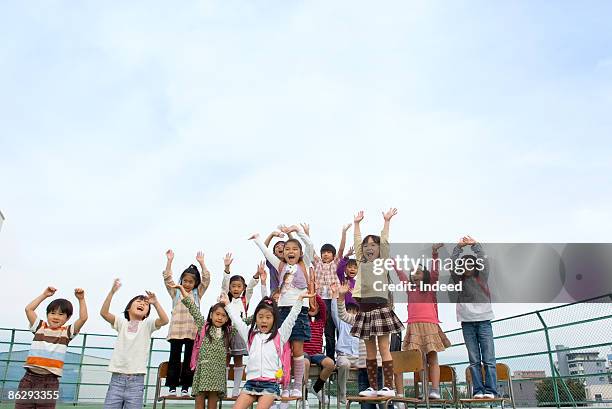 school children (5-11) waving hands - hyper japan stock pictures, royalty-free photos & images