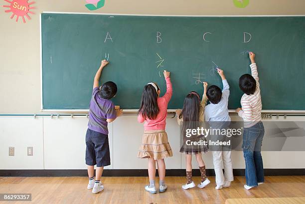 school children (6-9) writing on blackbaord - japanese elementary school bildbanksfoton och bilder