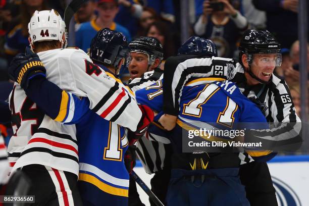 Linesman Pierre Racicot breaks up a scuffle between the St. Louis Blues and the Chicago Blackhawks in the third period at the Scottrade Center on...