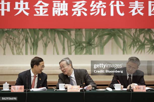 Zhou Xiaochuan, governor of the People's Bank of China , center, speaks with Liu Shiyu, chairman of the China Securities Regulatory Commission, left,...